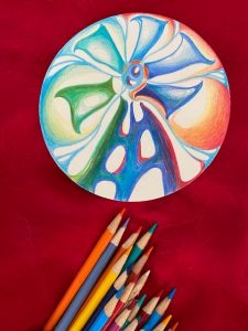 rainbow windmill with colored pencils below it on red backdrop